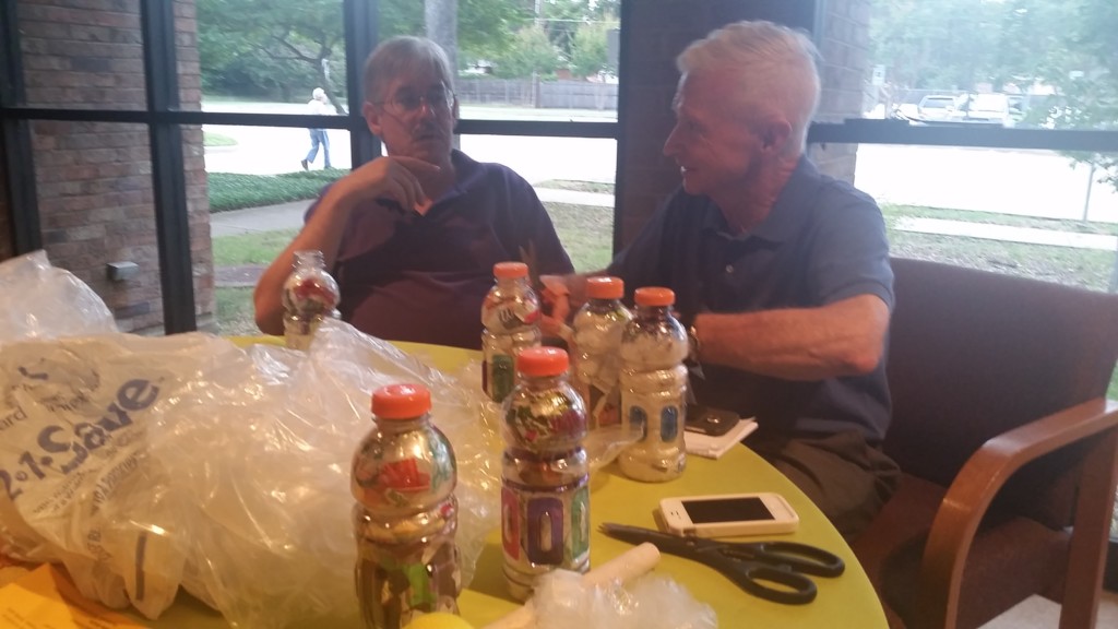 Dr. Charles Barker and Ron Bemis of Compassionate DFW stuff Gatorade bottles with discarded plastic scraps to create bricks.